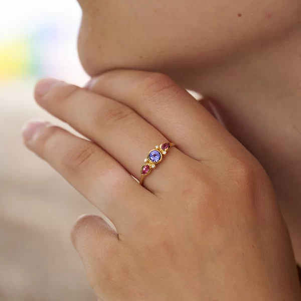 bague en or jaune 18 avec une pierre ronde en tanzanite bleu, deux marquise en saphir rose et quatre diamants