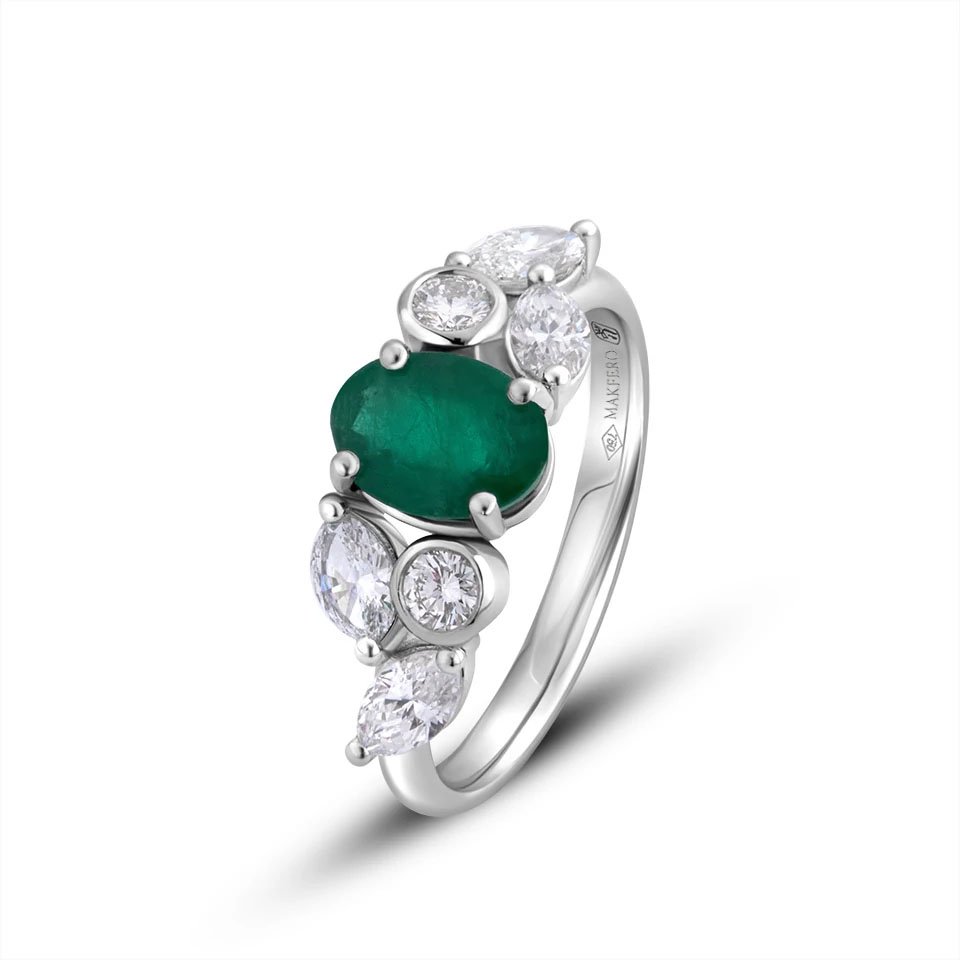 White gold ring with an oval emerald, 7.75 × 5.75 mm, two round diamonds, and four marquise diamonds in a floral design