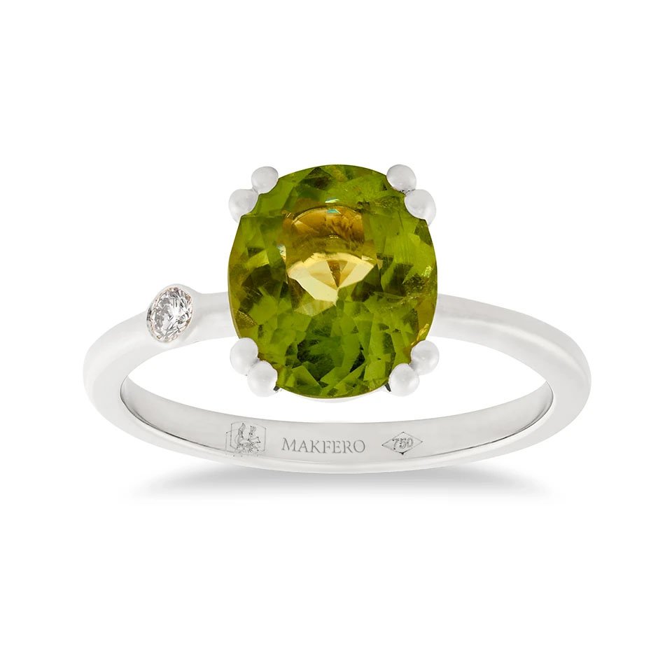White gold ring with oval peridot and a single round diamond set on the band