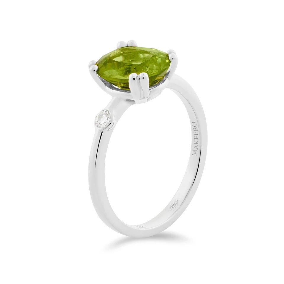 White gold ring with oval peridot and a single round diamond set on the band