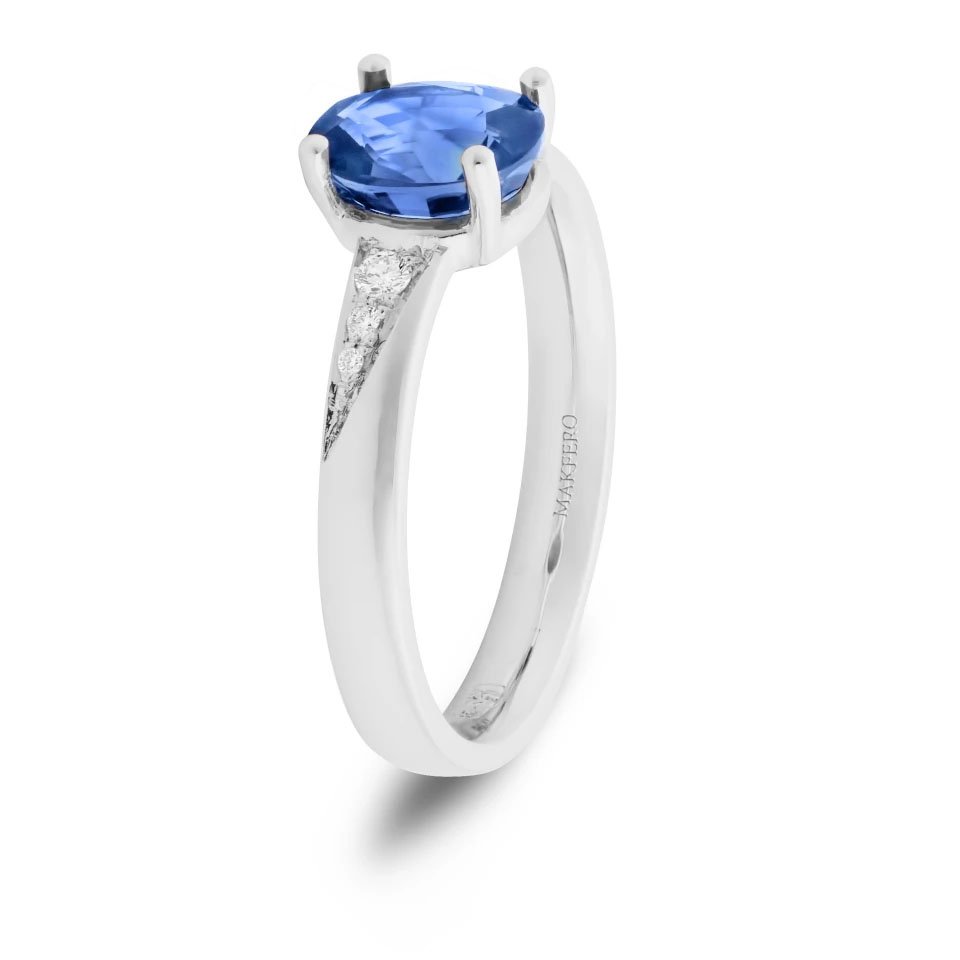 White gold ring with an oval sapphire, 7.25 × 6 mm, and six small round diamonds on the band