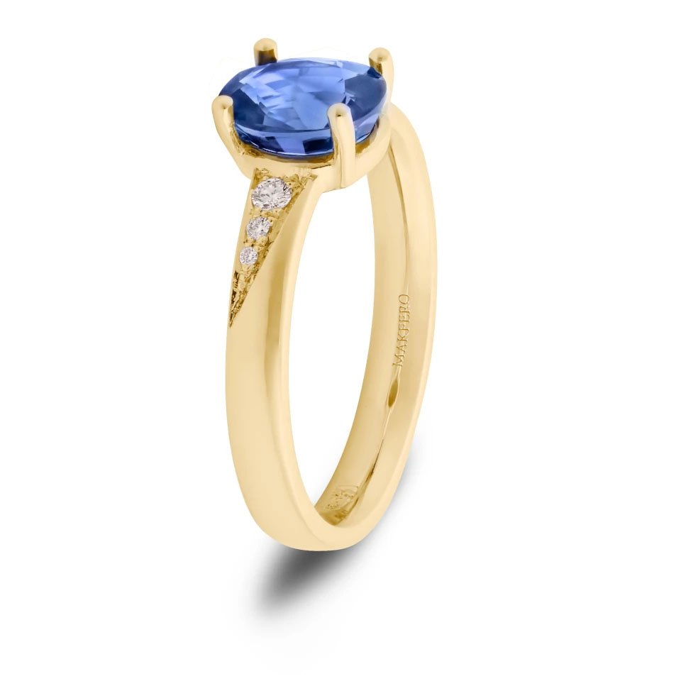 Yellow gold ring with an oval sapphire, 7.25 × 6 mm, and six small round diamonds on the band
