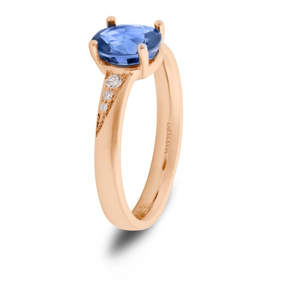 Rose gold ring with an oval sapphire, 7.25 × 6 mm, and six small round diamonds on the band
