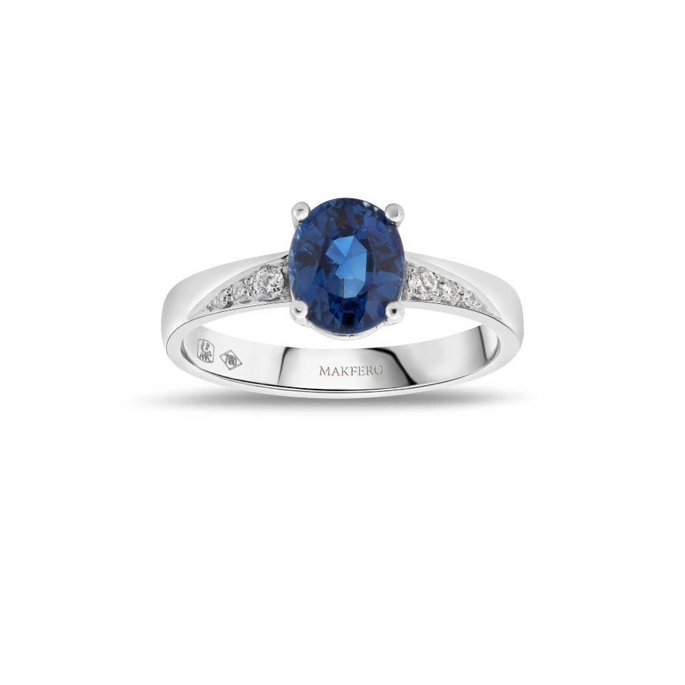 White gold ring with an oval sapphire, 7.25 × 6 mm, and six small round diamonds on the band