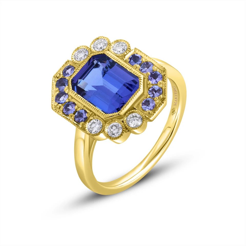 Yellow gold ring with a central emerald-cut tanzanite, 7 × 9 mm, surrounded by six round diamonds and ten round tanzanites in a geometric halo design