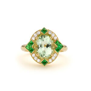 Yellow gold ring with an oval green tourmaline, surrounded by diamonds and accented with green tsavorites in a geometric halo
